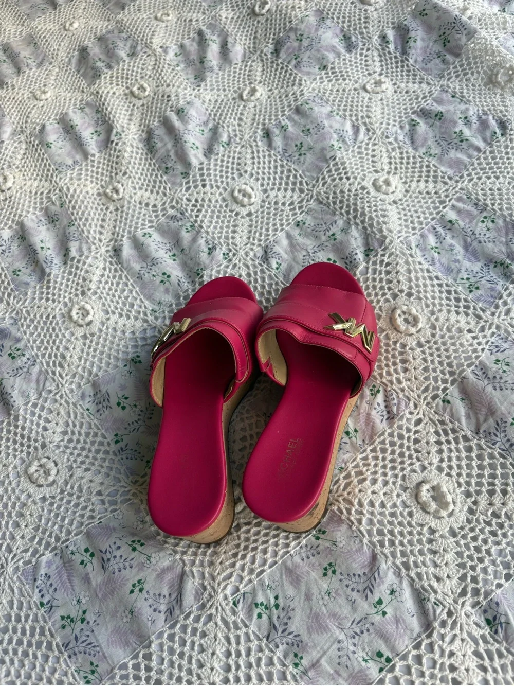 Michael Kors bright pink platform slide sandals with a cork wedge.